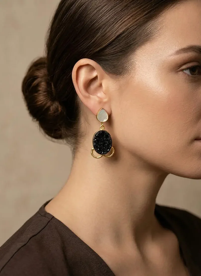 Mother of pearl stud with black druzy stone hanging earrings on a gold base.