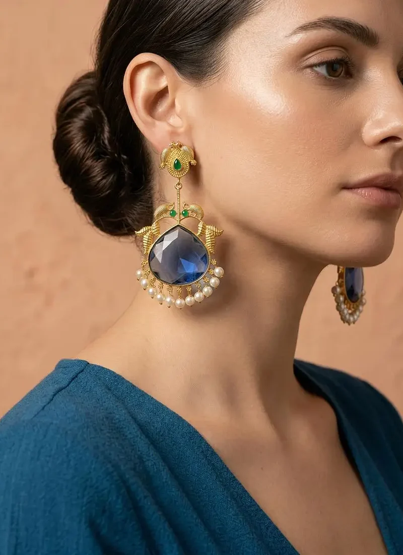 Golden peacock adorned with a striking blue agate stone with delicate pearl danglings