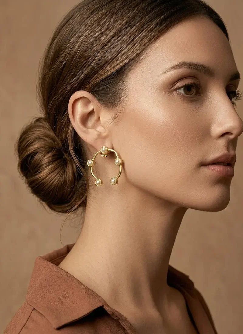 Gold hoop earrings adorned with delicate shell pearls.
