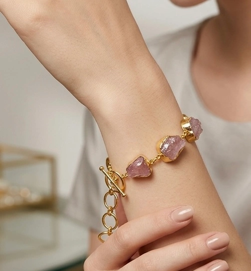 Rose quartz stone bracelet in elegant gold-tone setting.