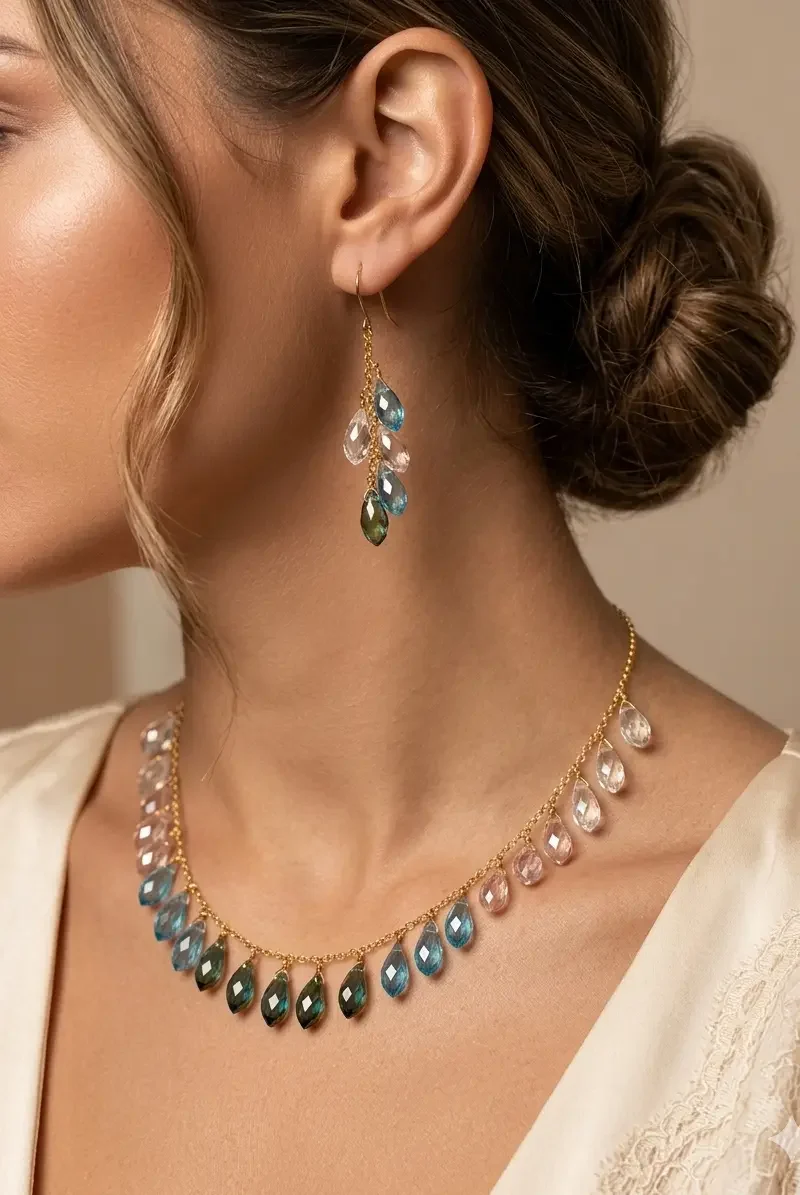 Delicate gold plated set featuring multi-color crystal drops with coordinating earrings and bracelet.