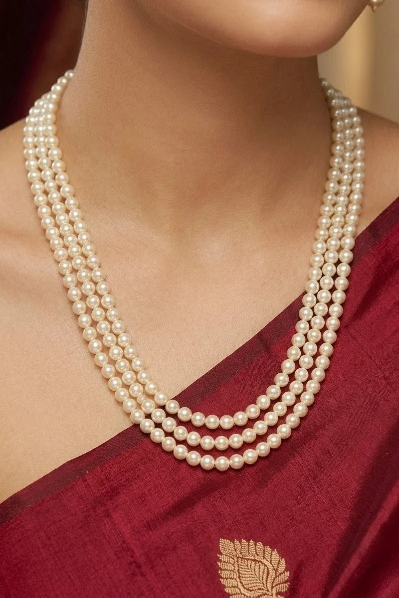 Three-layer round shell pearl necklace, designed at a classic 18-inch length.