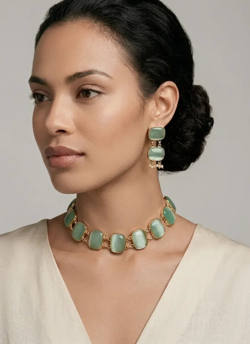 Gold necklace set featuring soft green Monalisa stones, paired with matching drop earrings.