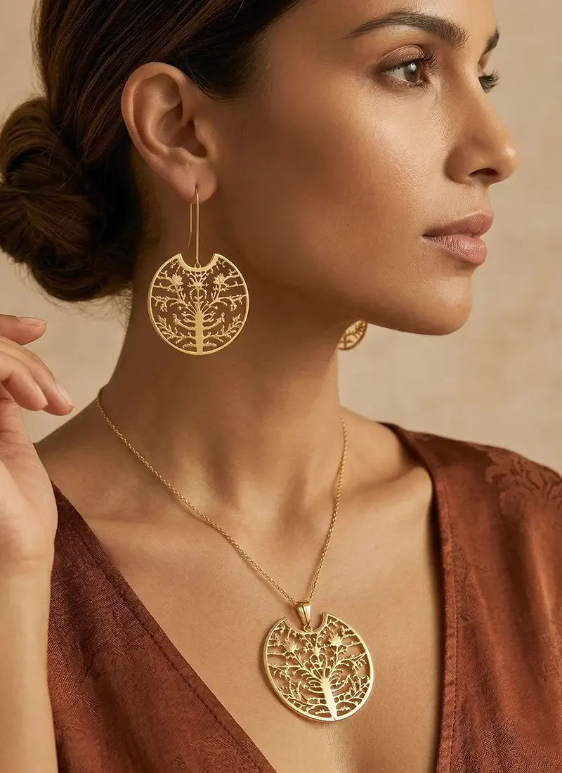 Elegant gold chain featuring a round pendant with intricate filigree work, paired with matching earrings.